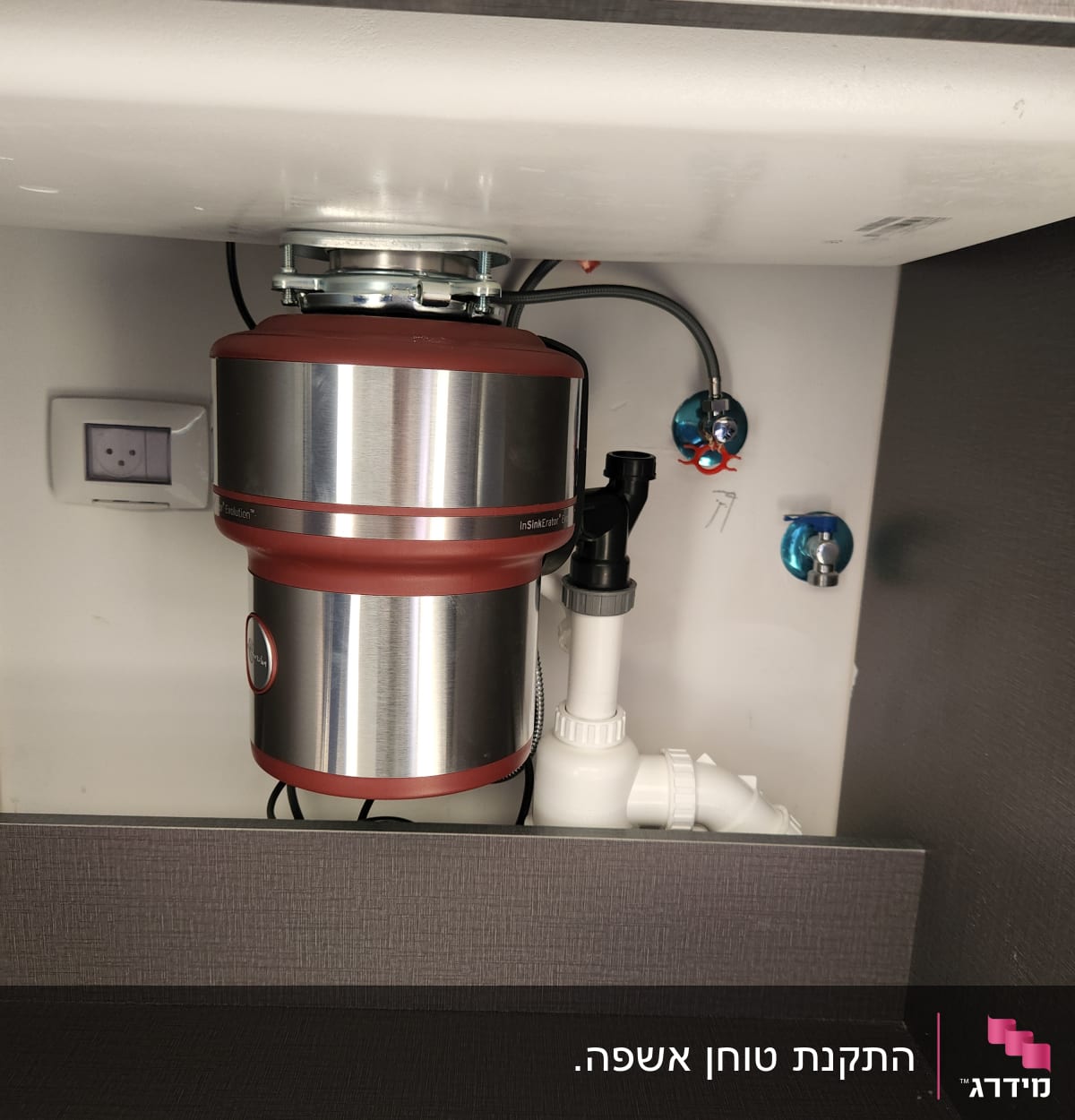 מכשיר טוחן אשפה מותקן מתחת לכיור במטבח